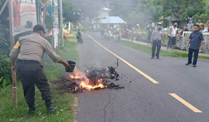 Personil Polsek Tabut Sedang Berusaha Memadamkan Api Dari Sepeda Motor