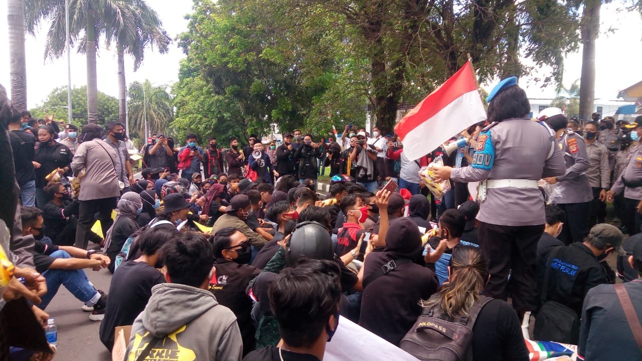 Peserta Unras mendapatkan air mineral dan makanan dari Polwan Polres Bitung.